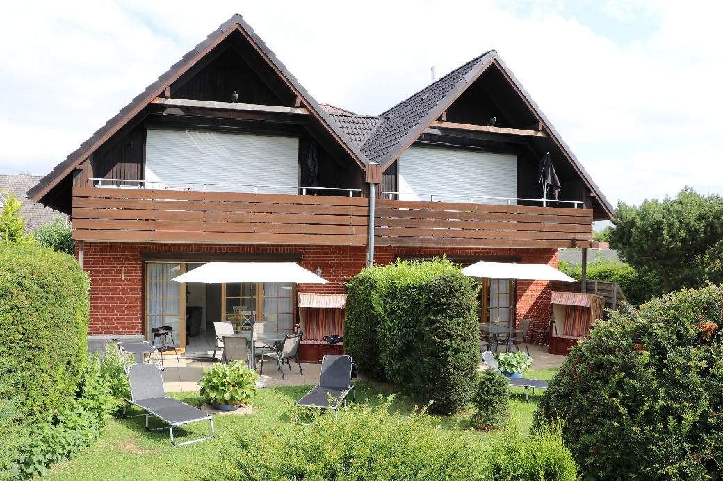 Rückansicht von Haus Henning mit den Balkonen und dem Garten.